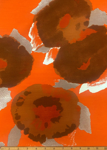 Patterned fabric with brown shapes on an orange background, featuring a ruler at the bottom for scale.